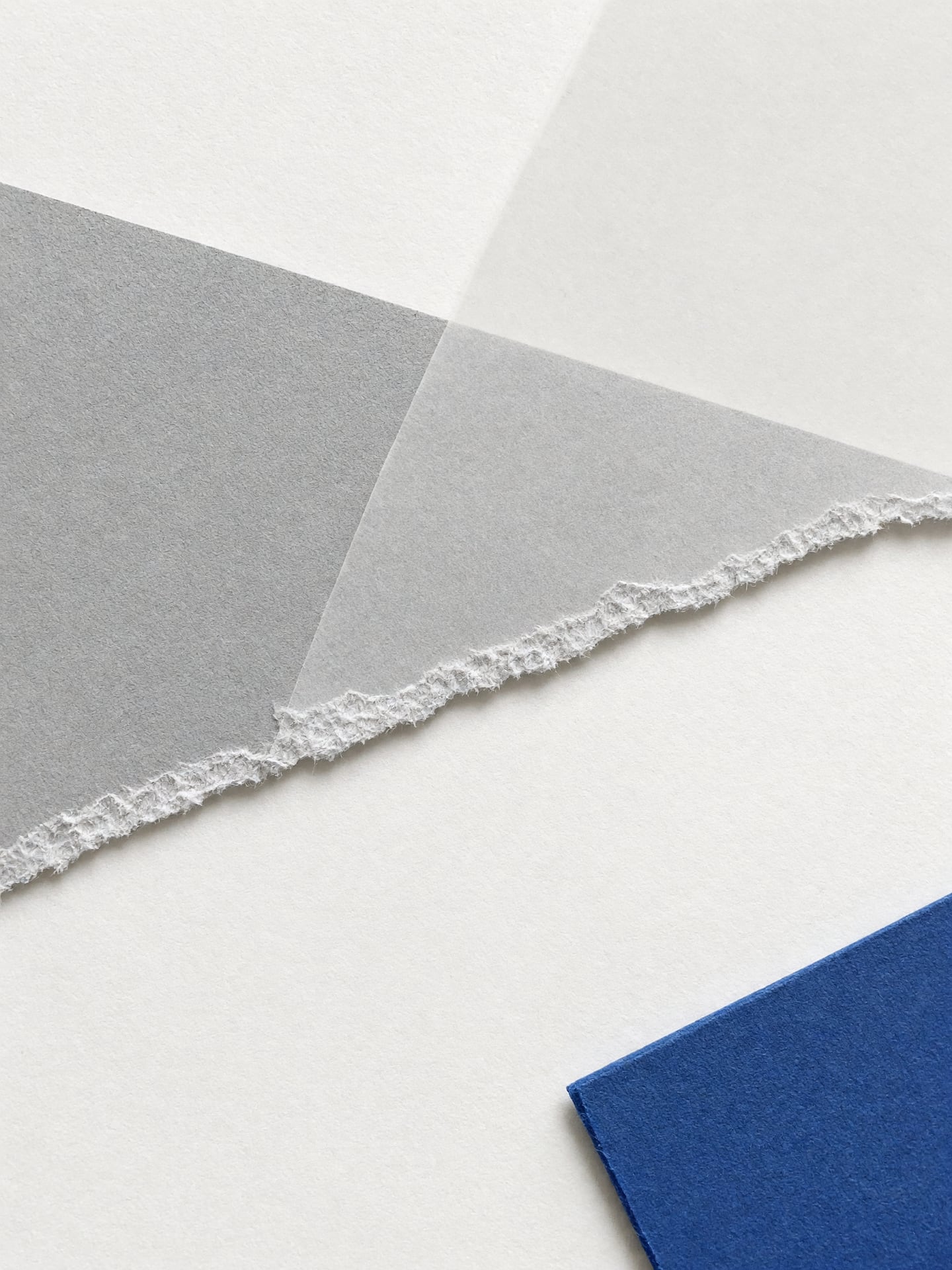 Nahaufnahme einer Schnittkante im Papier, daneben eine Lage Transparentpapier.